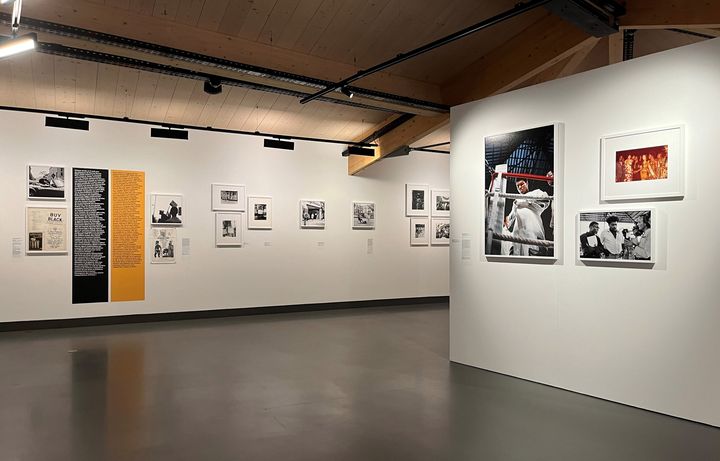 Une vue de l'exposition "Kwame Brathwaite : Black is Beautiful" au Centre national de la photographie de Mougins, avec, au premier plan, une photo en couleurs du boxeur Muhammad Ali lors du "combat du siècle" à Kinshasa en 1974. (LAURE NARLIAN / FRANCEINFO CULTURE)
