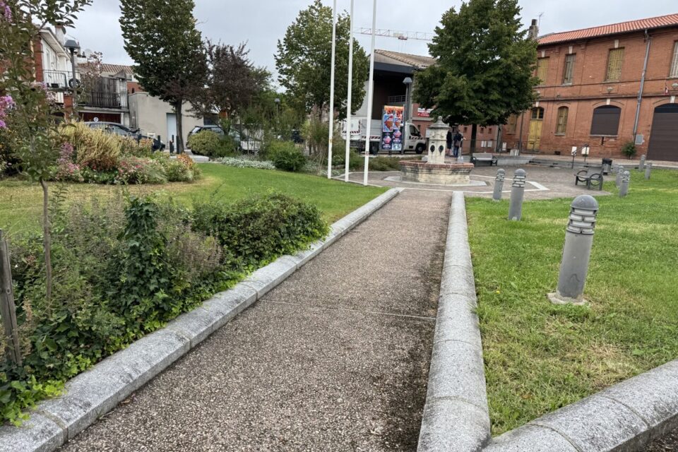 Pojur l'heure, deux allées pavées amènent à une fontaine entourée de massifs de fleurs et de pelouse.