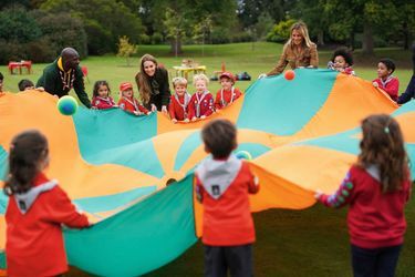 La princesse et son invitée se mêlent à un jeu scout: faire sauter des ballons à l’aide d’un parachute. À Windsor, sur le terrain de Frogmore Cottage.
