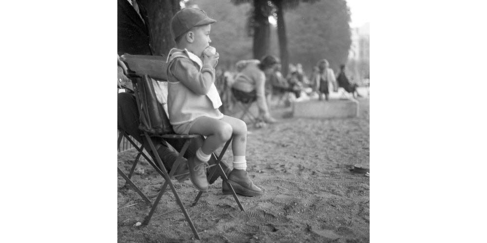 Scène de vie place Bellecour dans laquelle un petit gone dévore son goûter, 16 octobre 1961. Archives Le Progrès