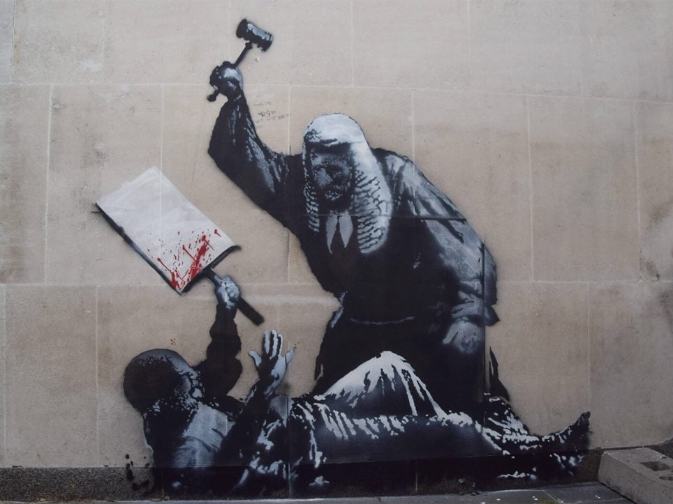 La dernière œuvre de Banksy apparue sur un mur de la Royal Courts of Justice, représentant un juge frappant un manifestant avec un marteau