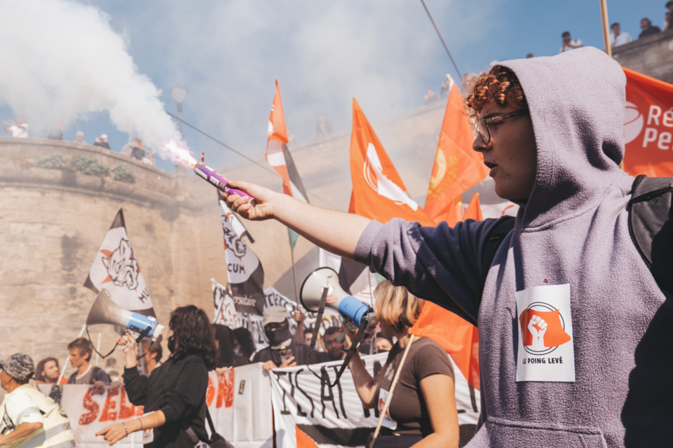 Des fumées rouges enveloppent la rue et donnent une atmosphère de brasier.