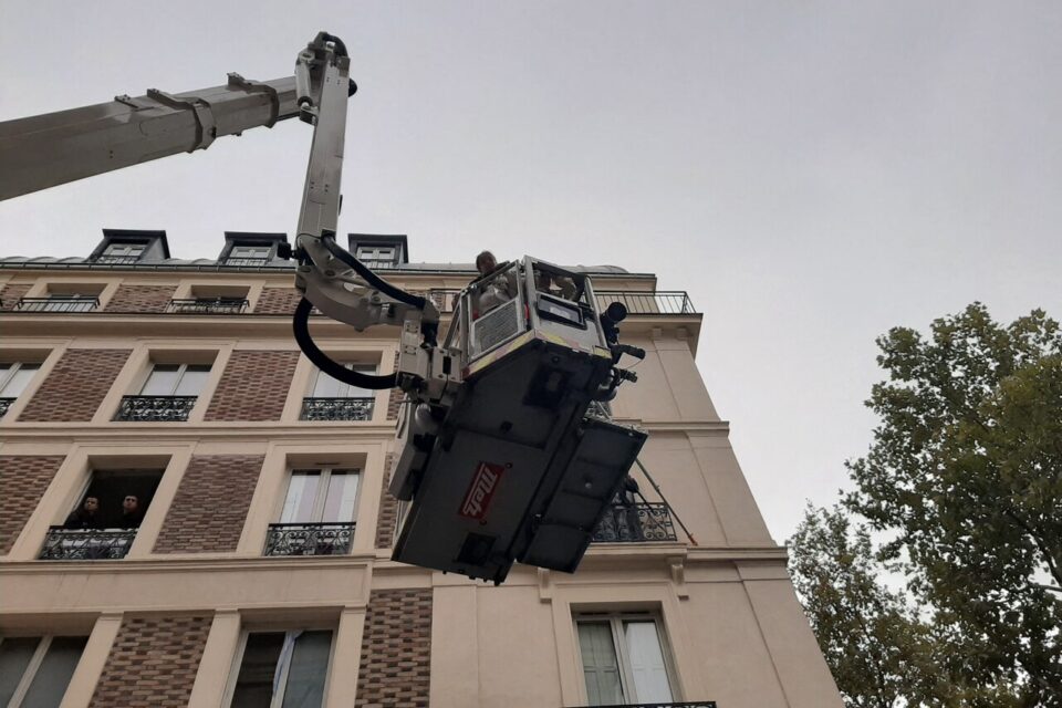 Des enfants évacués du 109 rue de l'Hôtel de Ville par bras élévateur articulé.