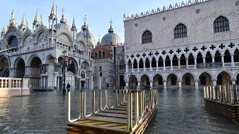 Des ponts à tréteaux sont empilés sur la place Saint-Marc inondée lors d'une marée haute de 1,44 mètre (4,72 pieds), à Venise, en Italie, lundi 23 décembre 2019.