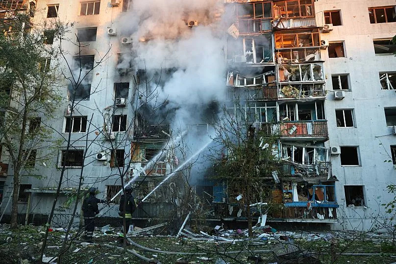 Des secouristes éteignent l'incendie d'une maison détruite par une frappe russe à Zaporijjia, le 28 septembre 2025.