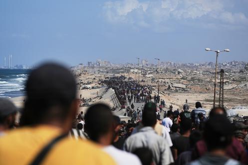 Des Palestiniens marchent le long de la route côtière de la bande de Gaza, en direction du nord, le 10 octobre 2025.