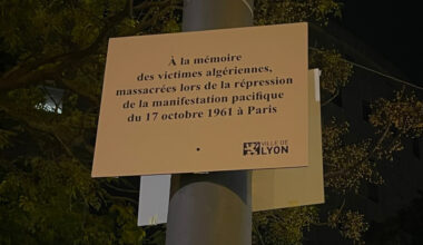 une plaque commémorative envers les victimes du massacre du 17 octobre 1961 recouverte par un hommage à Lola