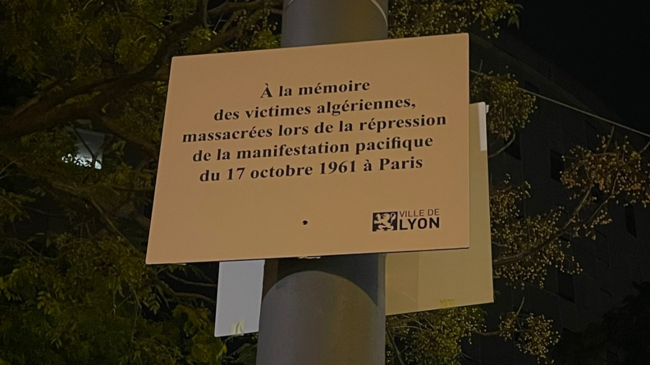 une plaque commémorative envers les victimes du massacre du 17 octobre 1961 recouverte par un hommage à Lola