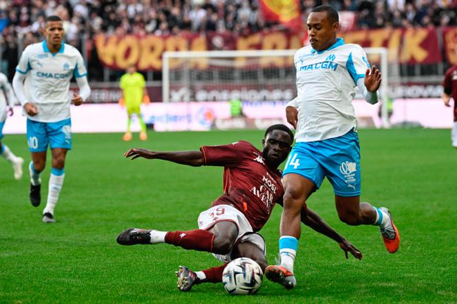 L’attaquant de l’OM Igor Paixao (maillot blanc) taclé par le défenseur messin Koffi Kouao, au Stade Saint-Symphorien, à Metz, le 4 octobre 2025.