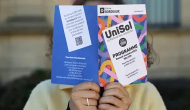 Photo d'une personne lisant le flyer de l'événement Unisol