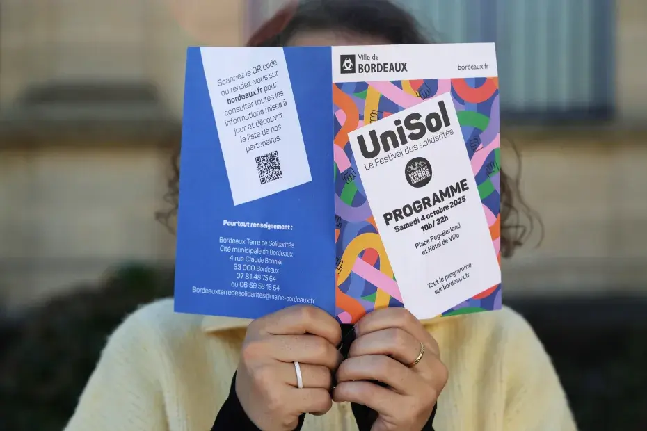 Photo d'une personne lisant le flyer de l'événement Unisol