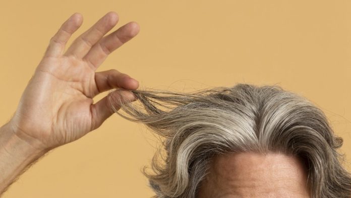 Et si vos cheveux gris étaient le signe d’une défense naturelle contre le cancer Ma Santé Un homme qui montre ses cheveux gris, signe de défense contre le cancer.