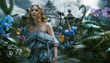 Poétique Mia Wasikowska, en robe à volants rayée de noir, dans l'Alice au pays des merveilles de Tim Burton.