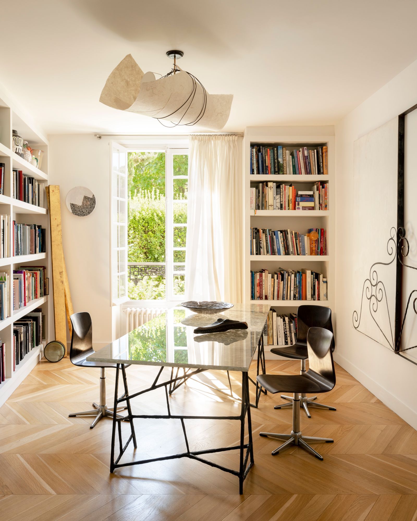 La salle à mangerbibliothèque ouverte sur la nature dvoile un plafonnier en papier roul et une table centrale Pina signs...