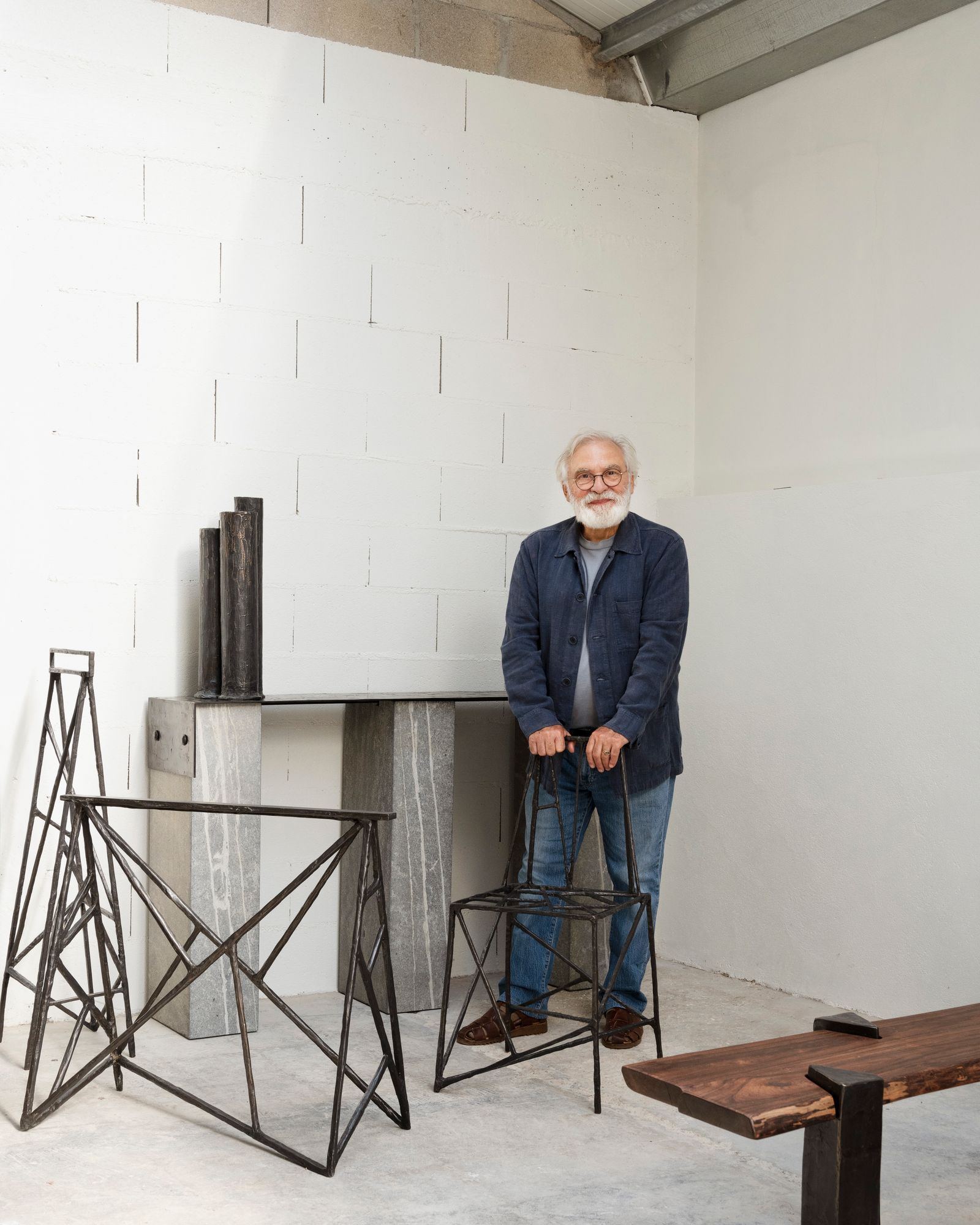Jean Grisoni pose dans son troisième atelier où il travaille le bois le mtal et la terre. Cet ancien garage cache aussi...