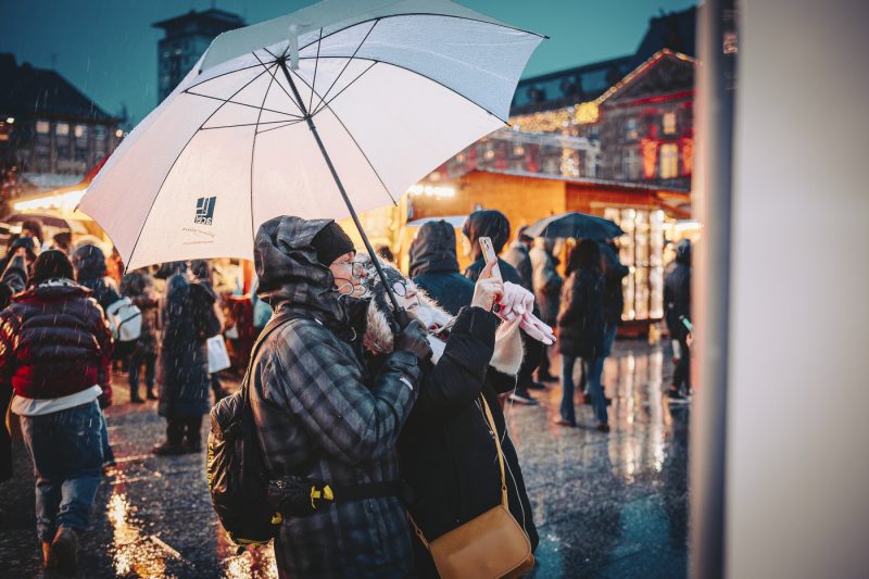 Marché de Noel 2024 avec gens sous parapluies place Kléber