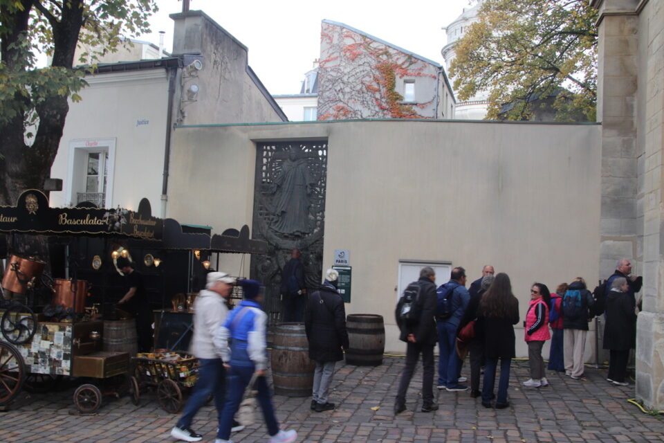 La porte en bronze du sculpteur italien Tommaso Gismondi reste fermée la plupart de l'année et les visiteurs de l'église Saint-Pierre de Montmartre passent souvent devant sans la remarquer.