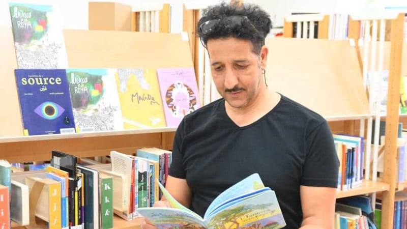 Le poète marseillais Mo Abbas, invité des OrnicARINKS, feuillette l’un de ses ouvrages exposés à la bibliothèque de Jouques.