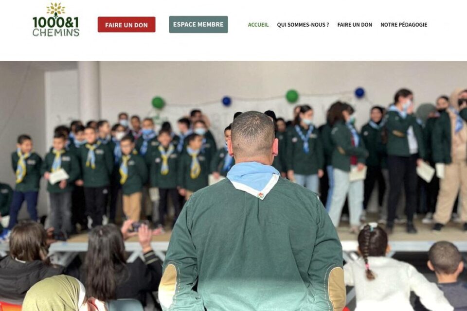 L'ancienne page d'accueil du site Internet 1000 et 1 chemins montrait une photo des scouts musulmans de France lors d'une cérémonie.