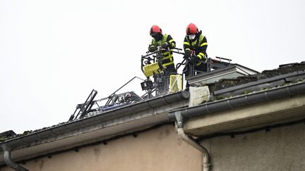 Des pompiers interviennent sur le site d'un incendie qui a fait cinq morts et un blessé, le 30 novembre 2025 à Neuves-Maisons (Meurthe-et-Moselle). (JEAN-CHRISTOPHE VERHAEGEN / AFP)