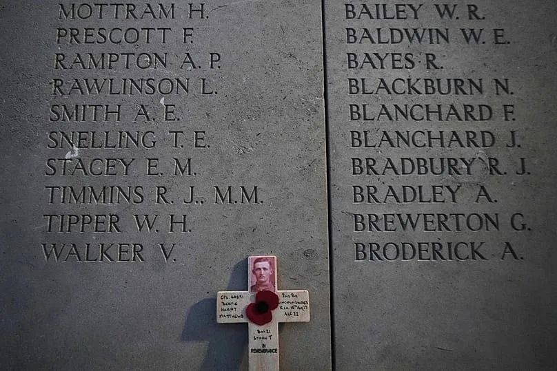 Une croix de bois est placée devant les noms des disparus de la Première Guerre mondiale avant la cérémonie de l'Armistice au Mémorial des disparus de la Porte de Menin, à Ypres, en Belgique.