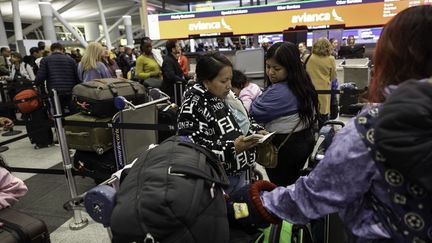 Des voyageurs à l'aéroport JFK de New York, le 26 octobre 2025. (JOHN MOORE / GETTY IMAGES NORTH AMERICA / AFP)