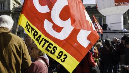 Des manifestants tiennent un drapeau de la CGT, Paris, 20 mars 2025. (ERIC BRONCARD / HANS LUCAS / AFP)