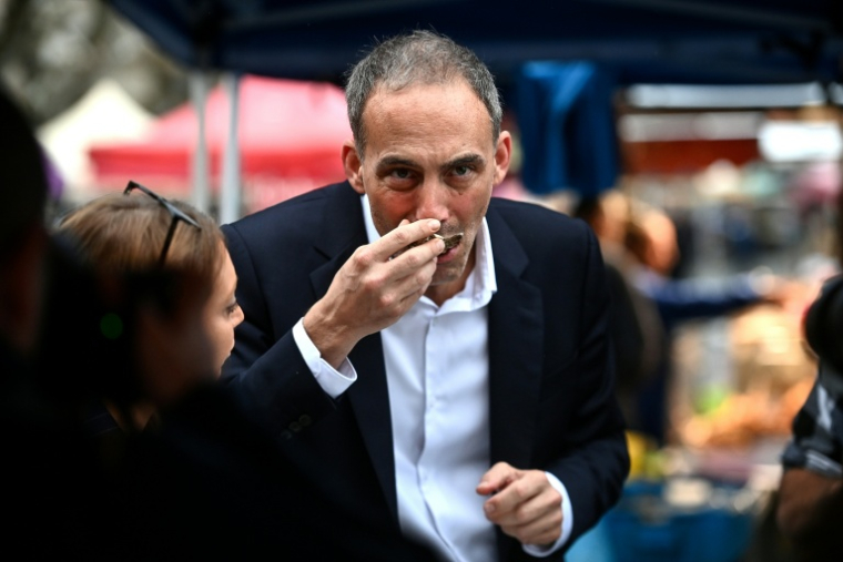 L'eurodéputé et leader de Place publique, Raphaël Glucksmann, déguste une huître lors de la visite d'un marché à La Réole (Gironde), le 4 octobre 2025 ( AFP / Christophe ARCHAMBAULT )