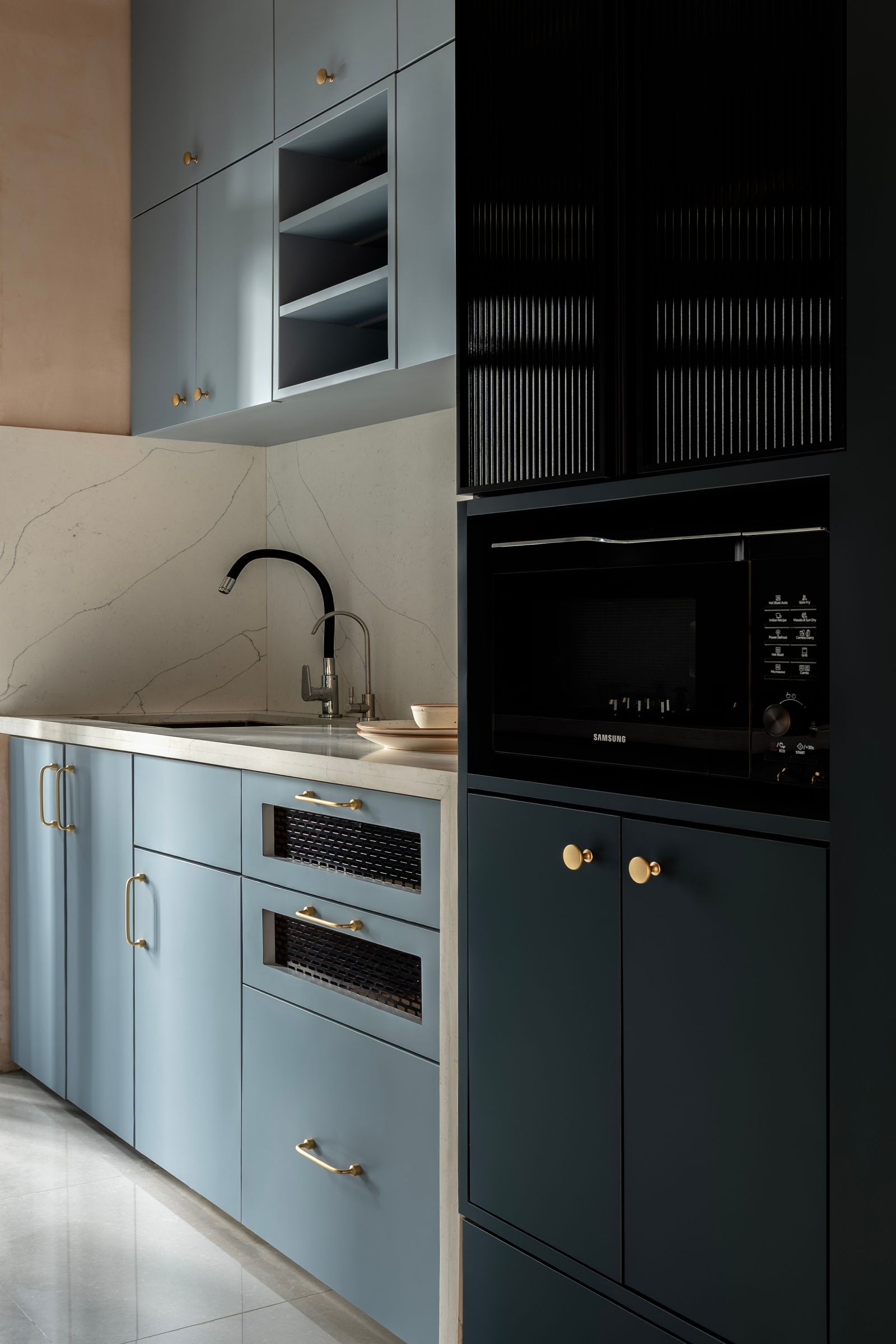 En contraste avec les tons chauds du bois naturel de la maison la cuisine modulaire bleu ardoise se distingue comme un...