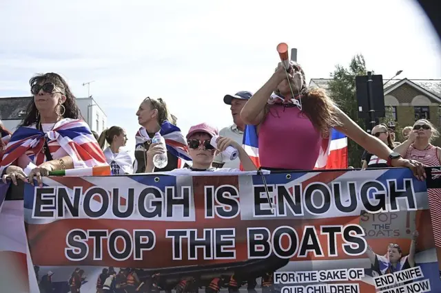 Des manifestants brandissant des drapeaux et des banderoles défilent dans les rues de Faversham, dans le Kent (Royaume-Uni), le 6 septembre 2025, lors d'une manifestation organisée par le groupe « STOP THE BOATS ». Cette manifestation intervient alors que des allégations font état de l'arrivée de plus de 50 000 migrants illégaux au Royaume-Uni sous le gouvernement travailliste du Premier ministre Sir Keir Starmer.