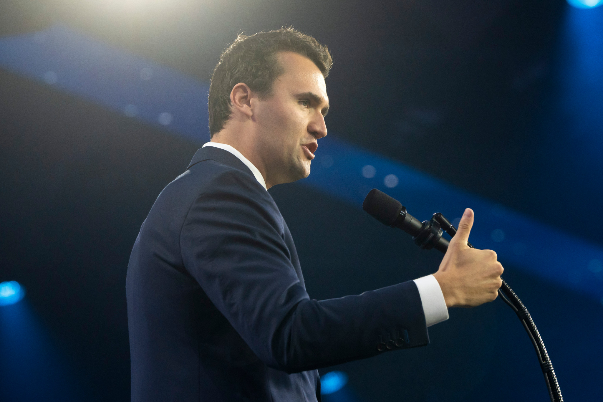 Charlie Kirk s’exprime lors du AmericaFest 2024 de Turning Point USA à Phoenix, en costume sombre, micro à la main. Charlie Kirk s’exprime lors du AmericaFest 2024 de Turning Point USA à Phoenix, en costume sombre, micro à la main.