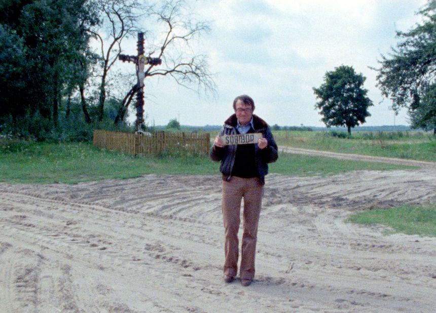 Claude Lanzmann tient en main une pancarte indiquant le village de Sobibor, lieu où fut construit un des centres de mise à mort de l’opération Reinhardt. Sobibor, Pologne, 1979.