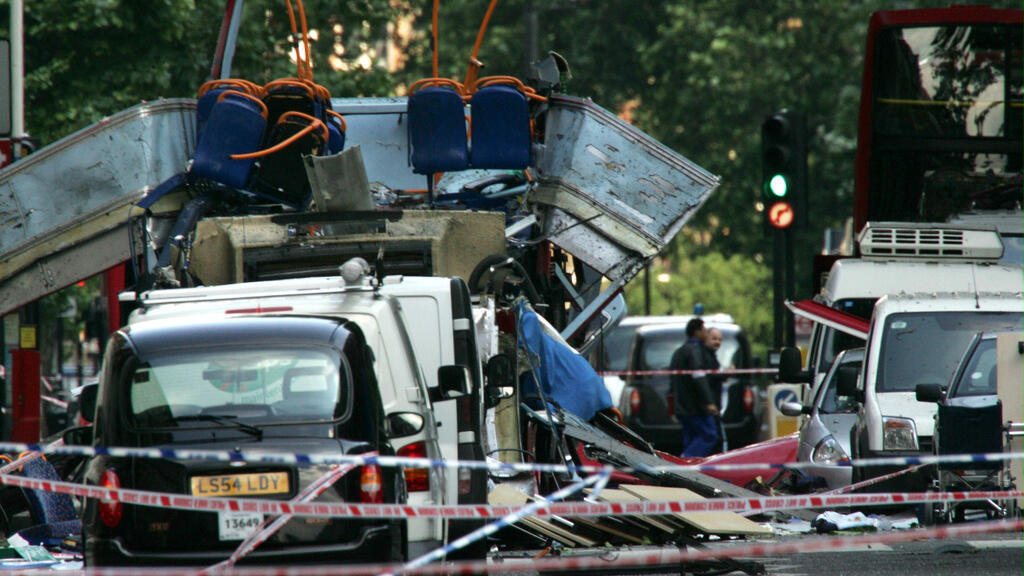Cette photo d'archives du 7 juillet 2005, montre l'épave d'un bus à impériale, le toit arraché par une bombe, et des voitures endommagées éparpillées sur la chaussée de Tavistock Square, dans le centre de Londres.