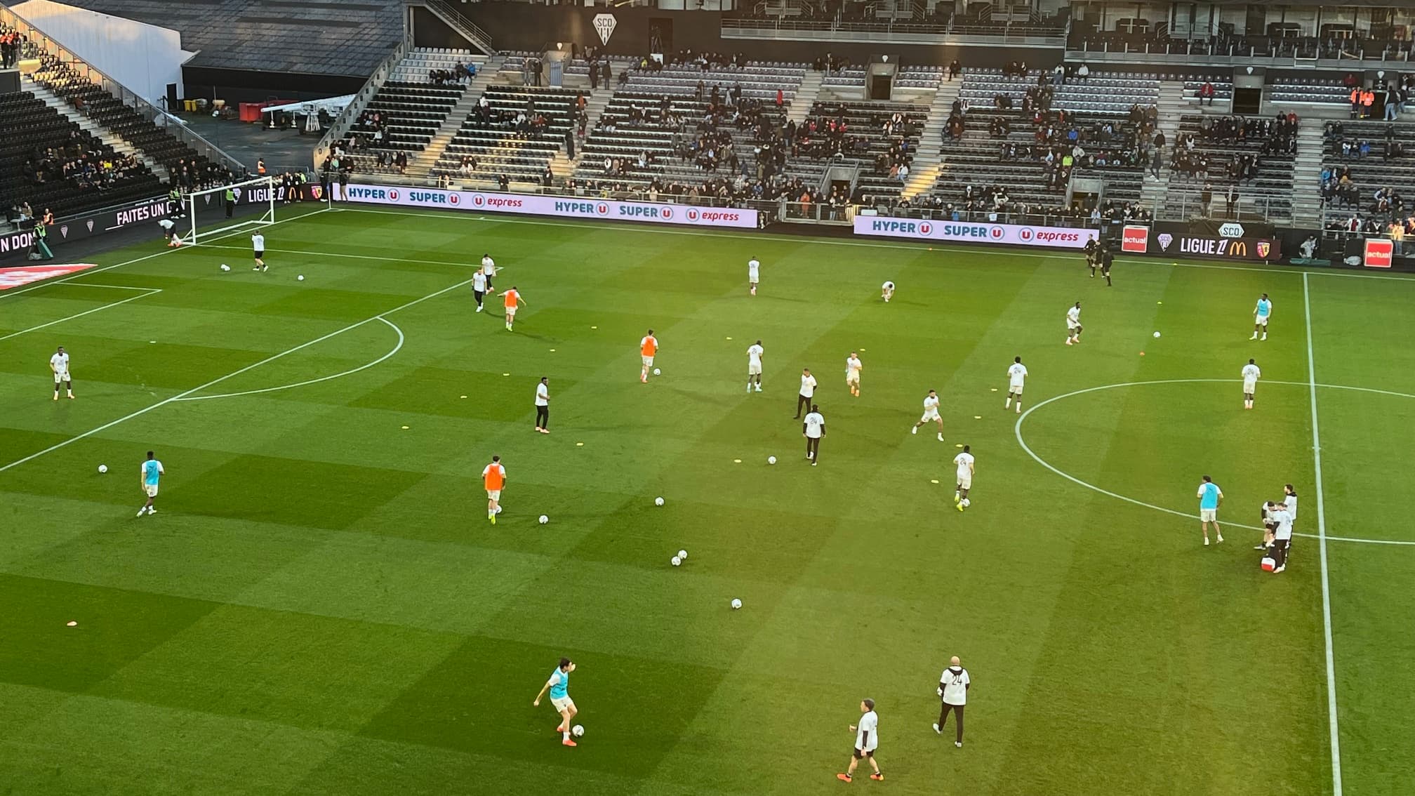 Les Lensois s'échauffent sur la pelouse d'Angers tous joueurs staff avec un t-shirt floqué 24 en soutien à Jonathan Gradit.