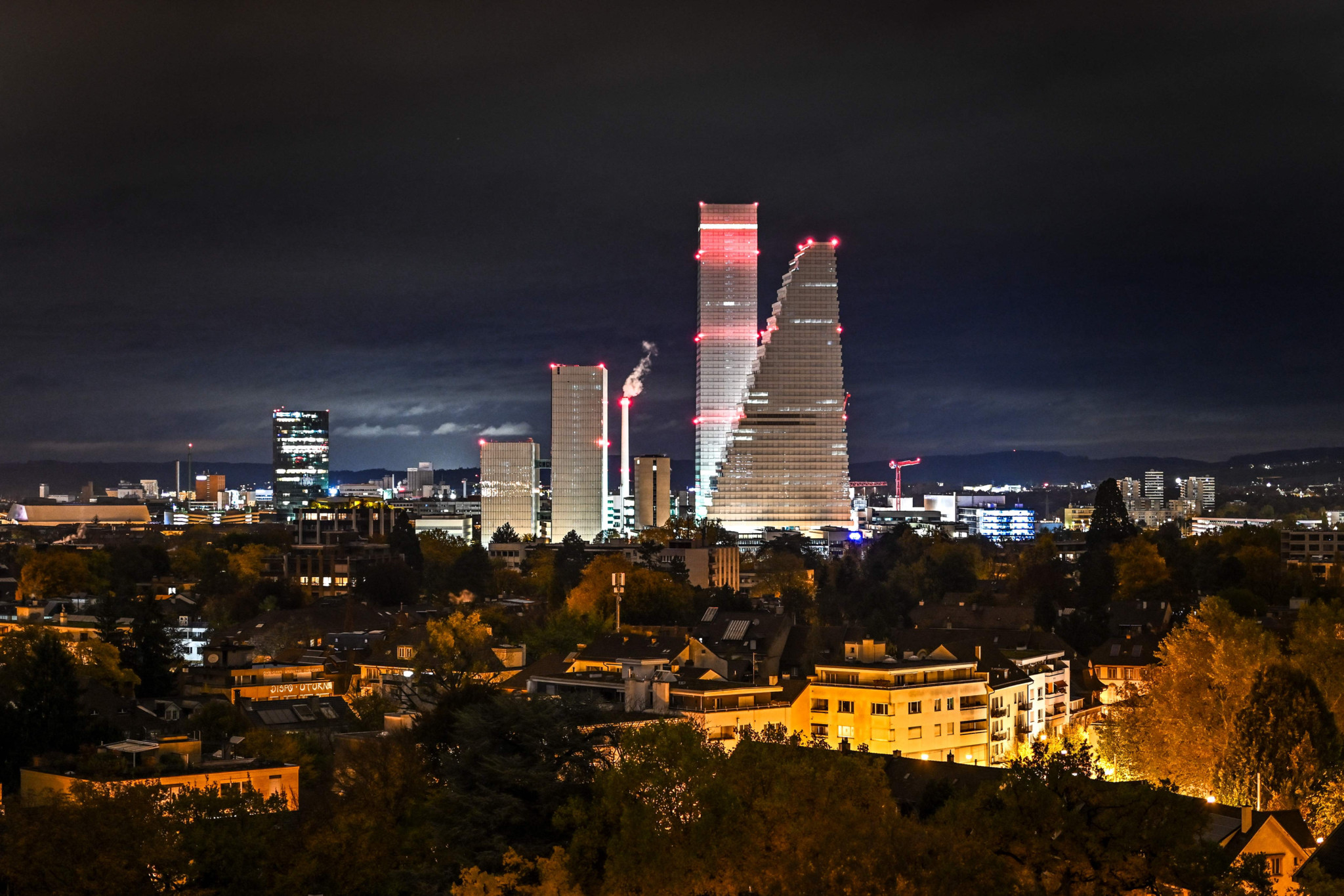 Les tours Roche illuminées à Bâle, conçues par Herzog et de Meuron, visibles la nuit du 25 octobre 2025.
