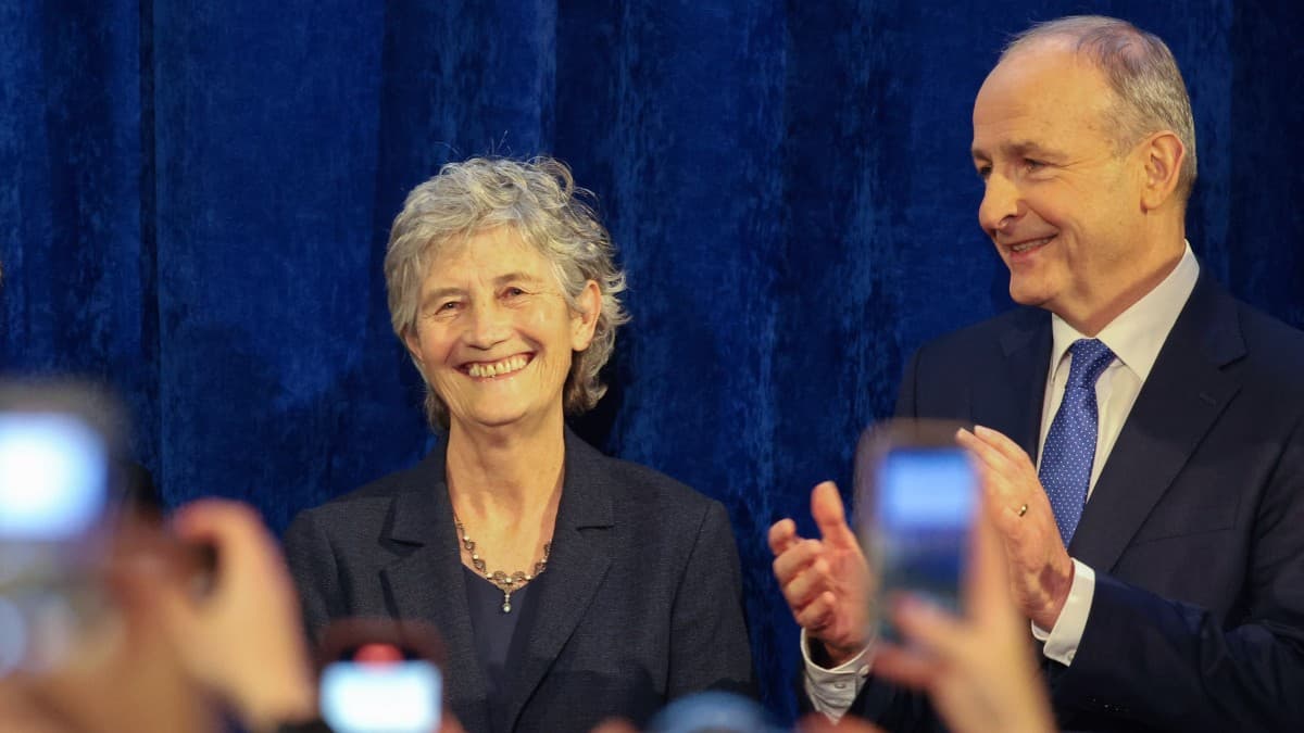 La présidente élue Catherine Connolly (à gauche) sourit aux médias aux côtés du Premier ministre irlandais Micheál Martin (à droite) après avoir été déclarée vainqueure de l'élection présidentielle irlandaise au château de Dublin, à Dublin, le 25 octobre 2025.