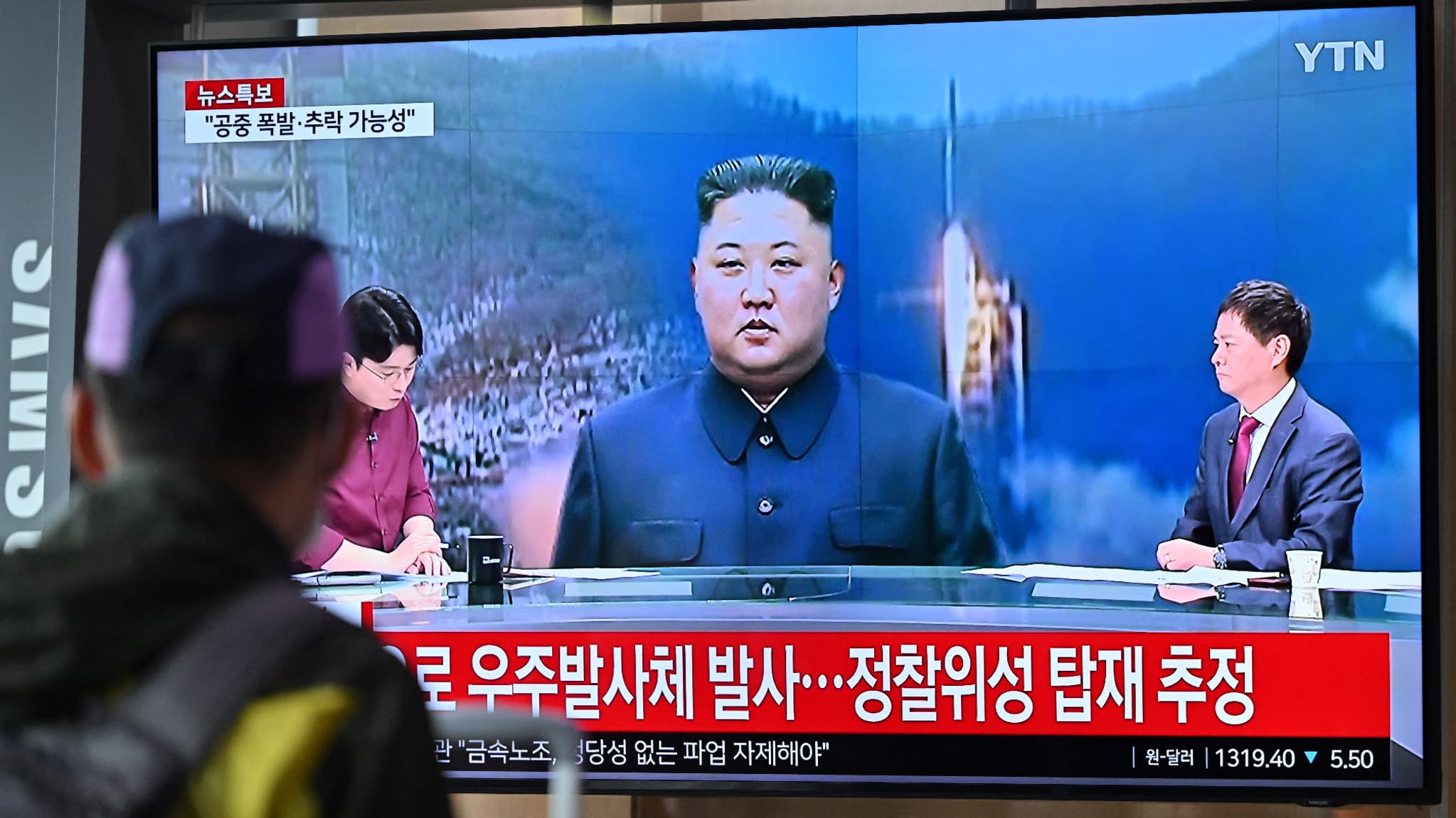 Un homme regarde un écran de télévision diffusant un bulletin d'information avec des images du dirigeant nord-coréen Kim Jong Un, à la gare de Séoul, le 31 mai 2023, le jour où la Corée du Nord a lancé un satellite qui s'est abîmé en mer.