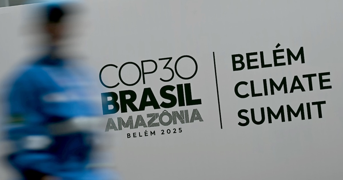 Une personne passe devant une affiche de la COP 30, à Belem au Brésil, le 5 novembre 2025