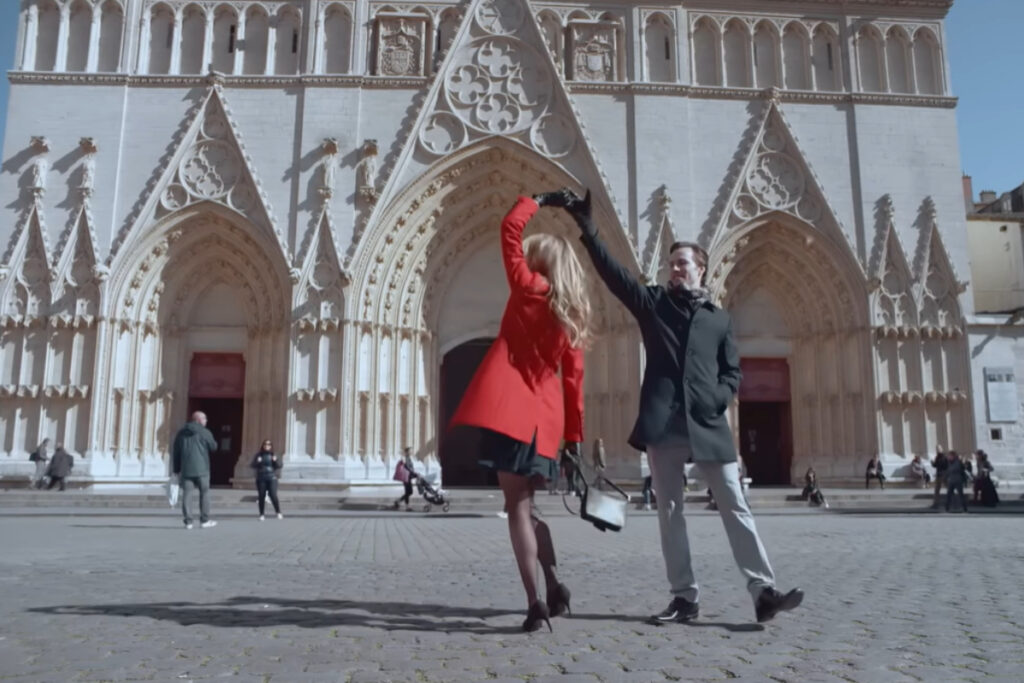 Photo de la scène d'un film où l'on voit un couple danser devant une église