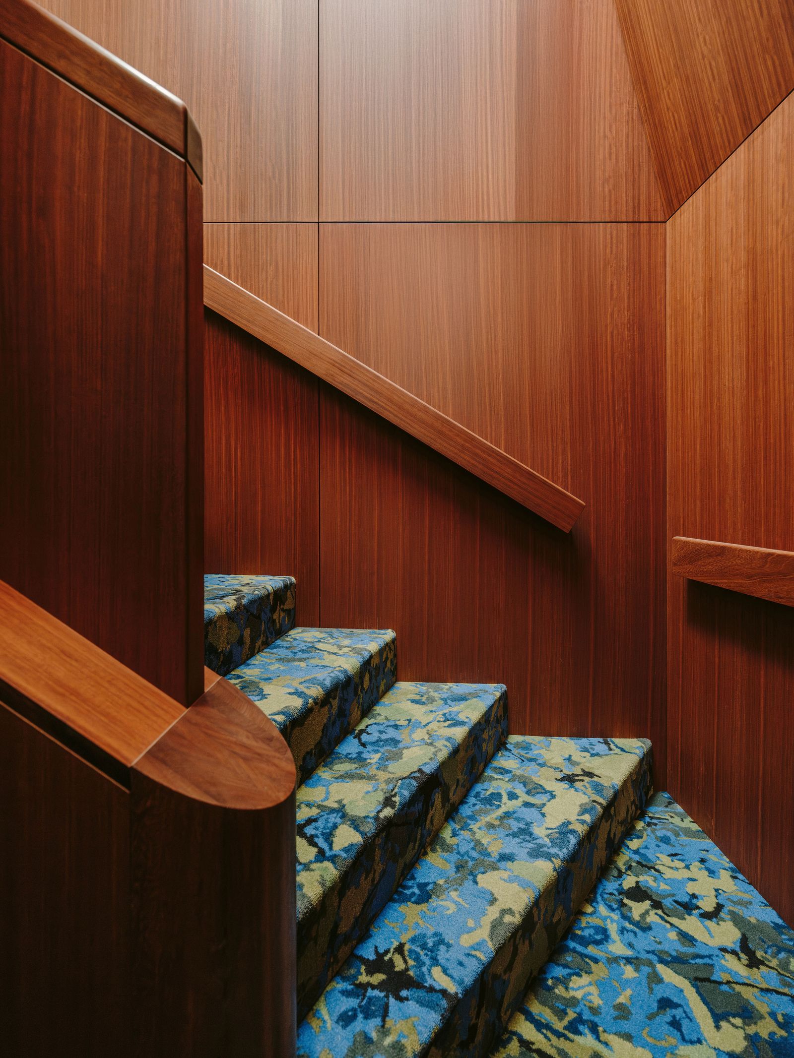 Lescalier menant à lappartement recouvert dune moquette à motifs bleus dEge Carpets.