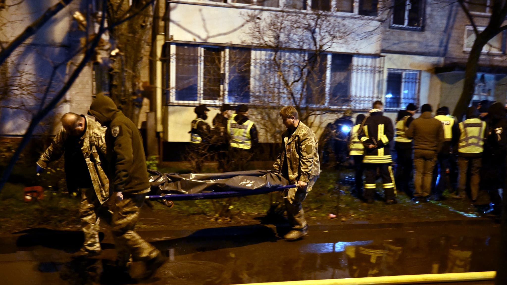 Des pompiers transportent un corps à l'extérieur d'un immeuble résidentiel après des frappes russes à Kiev le 25 novembre 2025.