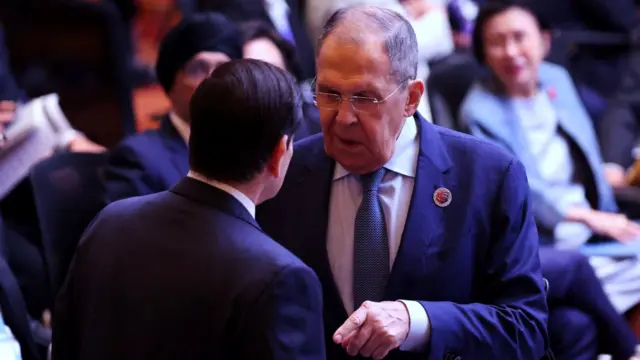 Le ministre russe des Affaires étrangères, Sergueï Lavrov, fait face à Rubio, la main tendue vers lui, lors de la 15e réunion des ministres des Affaires étrangères du Sommet de l'Asie de l'Est au Centre de conventions de Kuala Lumpur, capitale de la Malaisie, le 11 juillet 2025. D'autres délégués sont assis derrière eux.