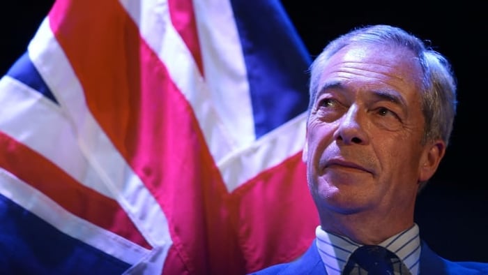 Le chef du parti Reform U K, Nigel Farage, devant un drapeau du Royaume-Uni.
