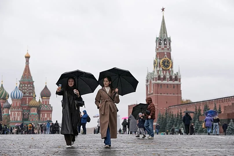 Des gens marchent sous la pluie sur la Place Rouge à Moscou, le 17 octobre 2025.