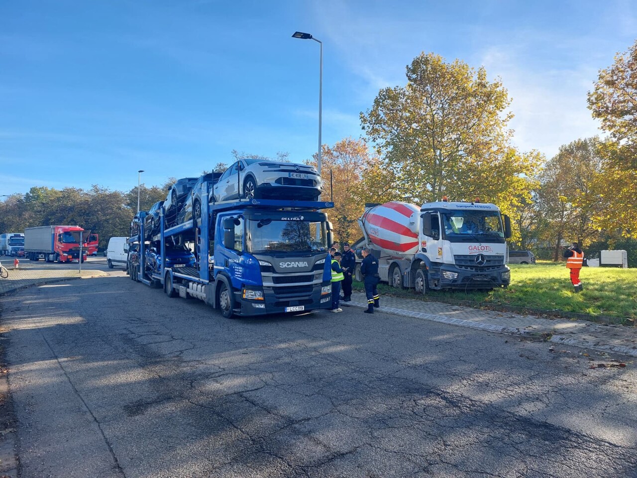un camion porte-voitures tombe en panne, un camion-toupie tente de le contourner et s'enlise