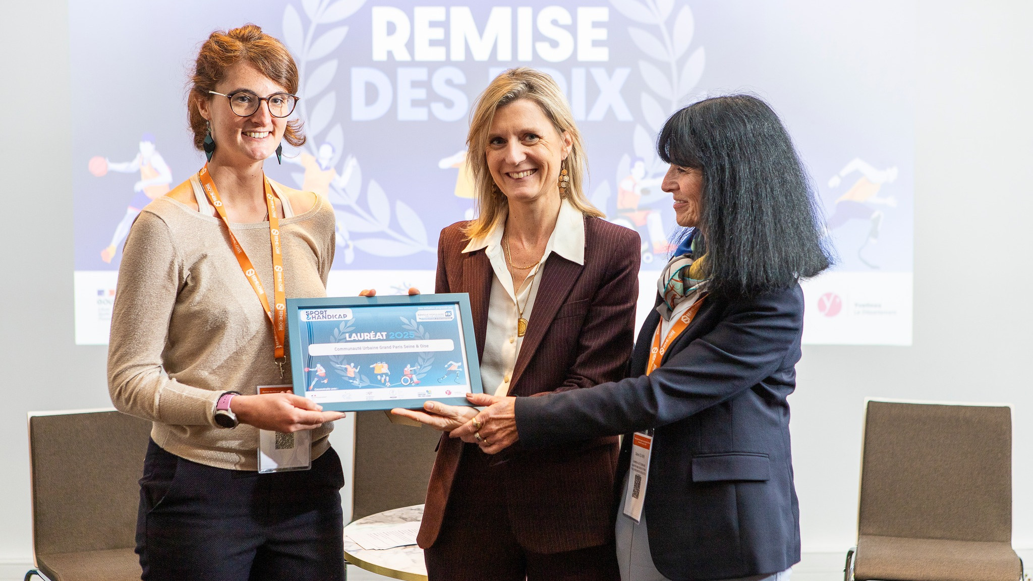 © Ludovic Letot - Tout sourire, Sabine Olivier, Vice-présidente GPS&O déléguée au sport (à gauche), reçoit le prix de la Fondation d’entreprise Banque Populaire Val de France pour le projet "Savoir Nager sport adapté".