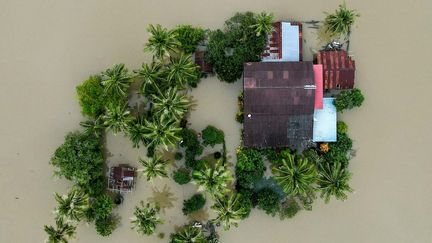 Le terrain d'une maison totalement inondé à Kangar, dans le nord de la Malaisie, après des pluies diluviennes et des inondations qui ont affecté des milliers de personnes dans la région, le 28 novembre 2025. (MOHD RASFAN / AFP)