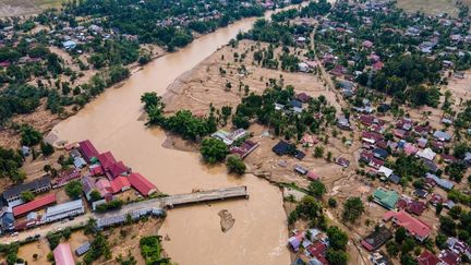 Une zone largement inondée et un pont détruit à Meureudu, dans la province d'Aceh (Indonésie), le 28 novembre 2025. (CHAIDEER MAHYUDDIN / AFP)
