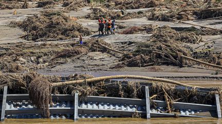 Des secouristes avancent à travers les débris pour évacuer une personne à Bireuen, dans la province d'Aceh (Indonésie), le 29 novembre 2025. La province a été gravement touchée par des inondations. (AMANDA JUFRIAN / AFP)