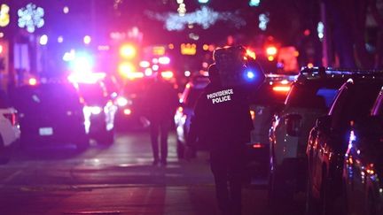 Des agents de police de la ville de Providence, dans l'Etat du Rhode Island aux Etats-Unis, où un tireur a tué deux personnes et blessé neuf autres sur le campus de l'université de Brown, le 13 décembre 2025. (KYLE MAZZA / ANADOLU / AFP)
